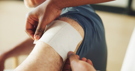 Hands, physiotherapy and patch on shoulder for injury, recovery and rehabilitation at clinic. Person, chiropractor and service for patient with pain, muscle ache or tape for wellness or inflammationの写真素材