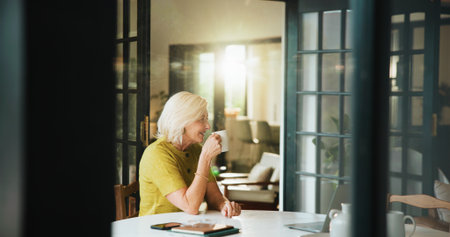 Coffee, thinking and smile with old woman in home for planning, relax and mindfulness. Reflection, vision and drinking tea with senior person and mug in apartment for calm, memory and beverageの写真素材