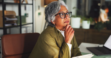 Tablet, thinking and reading with business woman in office for marketing campaign, night and news vision. Digital branding, reflection and research with mature employee in agency for article deadlineの写真素材