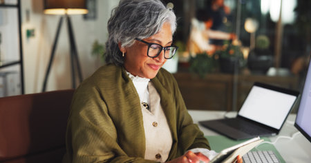 Tablet, smile and reading with business woman in office for marketing campaign, night and news vision. Digital branding, online and research with mature employee in media agency for article deadlineの写真素材
