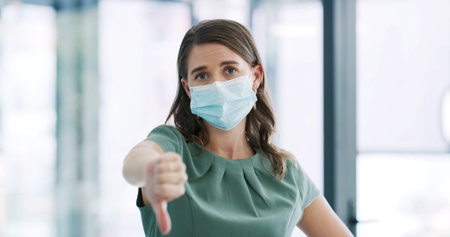 Woman, thumbs down and face mask for portrait in office for negative review, choice and symbol....
