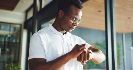 Black man, fitness and check smart watch in home for performance stats, workout results or heartbeat. Wristwatch, athlete and person in house with timer for exercise info, monitor health and wellnessの写真素材