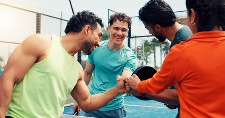 People, team and fist bump for padel, sports and excited for celebration, success or challenge for game. Men, woman and happy for support, training or achievement with contest on tennis court at clubの写真素材