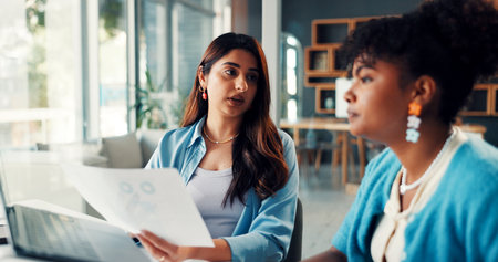 Sales consultant, paperwork and women in office, conversation and meeting for subscription increase. People, coworking or employees with documents, laptop and feedback with charts for profit growthの写真素材