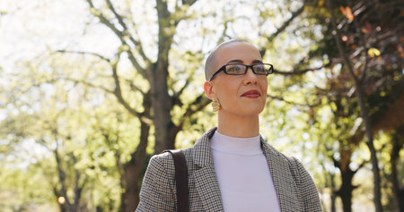 Thinking, walking and business woman in park for reflection, memory and vision on journey. Pride, commute and opportunity with person and idea outdoor for mindset, professional development and peaceの写真素材