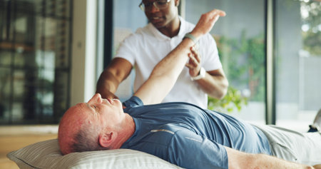 Arm, help and stretching with old man and physiotherapist for support, chiropractor and rehabilitation. Consulting, physical therapy and recovery with senior patient in clinic for healthcareの写真素材
