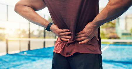 Hands, person and back pain on tennis court from fitness, match accident and muscle sprain. Player,...