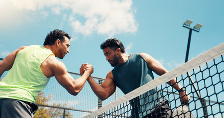 Men, handshake and padel with training, fitness and respect with support, challenge and low angle. People, athlete and shaking hands at tennis court for exercise, game and sports with match at clubの写真素材