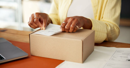 Box, label and logistics with hands of woman in office for shipping details, priority mail or info....