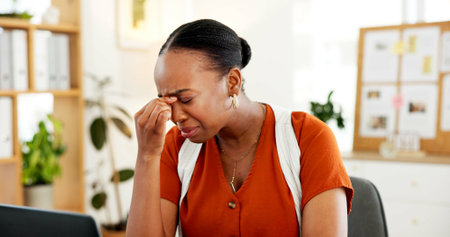 Fatigue, headache and black woman in office with deadline for creative project with mistake. Migraine, burnout and African female magazine editor with stress for article publishing in workplace.の写真素材
