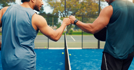 Hands, fist bump and padel with fitness, sports and respect with support, challenge and friends at game. People, athlete and training with success on tennis court, exercise or competition at clubの写真素材