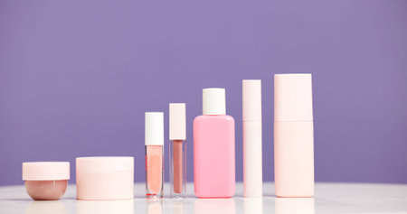 Makeup, bottles and product selection in studio for beauty aesthetic, skincare routine and marketing. Space, container or cosmetic range for dermatology, wellness or advertising on purple background.の写真素材