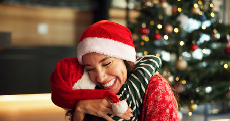 Christmas, mom and child hug in home for love, care and support with parent on holiday with bokeh. Xmas, happy mother and embrace girl for family connection, gratitude and thank you with daughterの写真素材