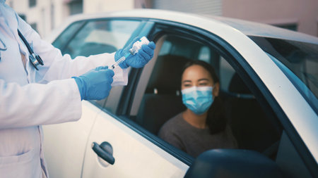 Healthcare, patient and hands with vaccine, car or injection for Covid prevention and communication. Drive medical help and consultation for RSV immunization, medicine and woman in vehicleの写真素材