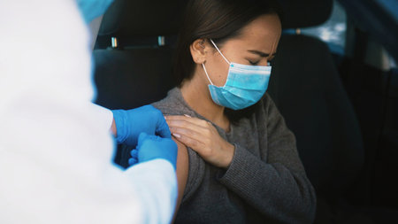 Patient, pain and hands with vaccine, car and healthcare for Covid 19 prevention, help and treatment. Drive thru, doctor and injection for RSV immunization, sore and booster for woman in vehicleの写真素材