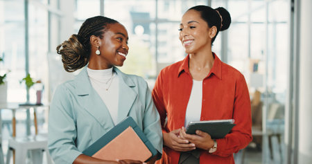 Media agency, tablet and women in office, teamwork and conversation with feedback for article. People, employees and journalists with discussion, smile and review for submission, planning or scheduleの写真素材