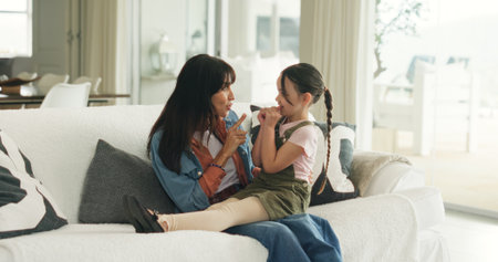 Relax, playful and mother with daughter on sofa of family home for bonding, support and love. Connection, happiness and affection with woman and child in living room of apartment for trust and careの写真素材