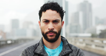 Serious, fitness and portrait of man in city with confidence for exercise, training and wellness. Runner, athlete and person in urban town for sports hobby, challenge and wellbeing for health outdoorの写真素材