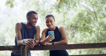 Hiking, nature and couple with cellphone on bridge, outdoor exercise or digital map for trail navigation. Fitness, step counter and people with mobile location app, fauna or flora research from belowの写真素材