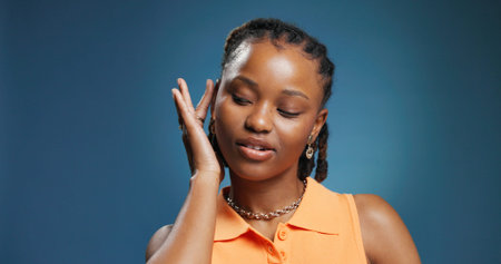 Confidence, style and attitude with black woman in studio for beauty, edgy and personality. Mockup space, pride and trendy with female person on blue background for aesthetic, cool and gen zの写真素材