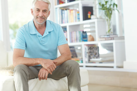 Portrait, man and relax on couch with smile for free time, wellness and peaceful weekend break....