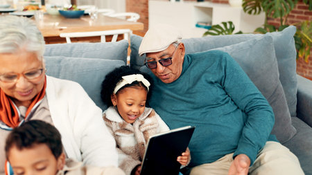 Grandparents, children and relax on sofa with tablet, care and bonding with movie in living room....