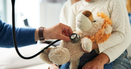Stuffed animal, stethoscope and hands with child in hospital for heartbeat, consulting and arrhythmia symptom. Medical advice, cardiology and pediatrician with doctor in clinic for support and toyの写真素材