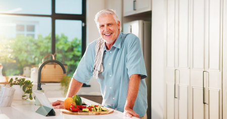 Old man, tablet and happy in kitchen with portrait, recipe and online course for dinner at house. Person, vegetables and ingredients in retirement with tech, smile or confident for cooking in Spainの写真素材