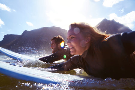 Smile, couple and surfing with surfboard in ocean for travel, fitness adventure and riding waves....