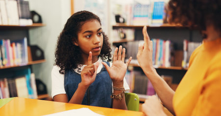 Woman, child and counting hands with teacher in library for homework, mathematics or learning. Female person, girl or student with educator, addition or subtraction for education, tutor or numbersの写真素材
