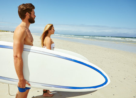 Surfer, couple and travel with beach, hobby and nature for ocean and holiday fitness. Man, woman and surfboard with space, cardio and vacation workout or tropical adventure with trip in Thailandの写真素材