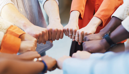 Business people, fist bump and huddle with diversity for unity, solidarity or mission. Group, employees or colleagues with hands together, support or trust for community circle, inclusion or equalityの写真素材
