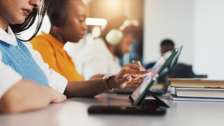 Tablet, hands and student in college for education, course research or scroll for knowledge. Tech, university and woman in classroom for studying, assignment info or test preparation for learningの写真素材