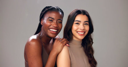 Happy women, portrait or hug with skincare, beauty or smile for cosmetics on a studio background. Female people, model or multiracial friends with care for cosmetology, inclusion or glowing skinの写真素材