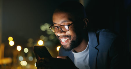 Texting, night and black man in city with phone, bokeh and funny chat on social media. Happy,...