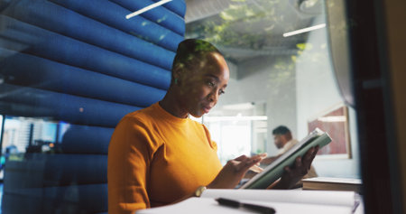 Pod, search and tablet with designer woman in office for project feedback, post or update. App, information and reading with employee person in cubicle of design workplace for planning or researchの写真素材