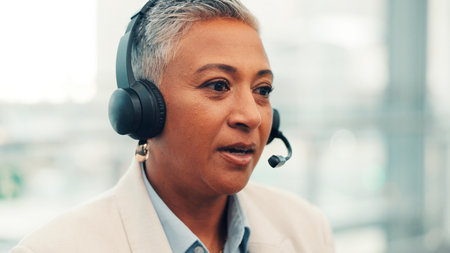 Mature woman, consultant and travel agency with headset for virtual asssistance or customer service. Female person, agent or employee talking with mic for schedule flight, help or telecommunicationsの写真素材