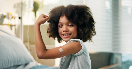 Happy boy, portrait and arm with band aid for vaccine, flu shot or immunity in hospital. Child, kid or youth with smile, flex or plaster for medical vaccination, healthcare visit or cure in clinicの写真素材