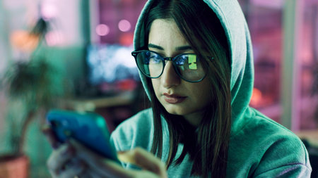 Night, hacker and woman with smartphone, glasses and online reading with cybersecurity programming. Person, reflection or programmer with cellphone, website server and eyewear with coding and privacyの写真素材