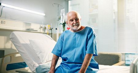 Thinking, patient and senior man in hospital, healthcare and happy for recovery on bed or treatment. Rehabilitation, health and old person with smile for discharge, reflection and wellness in clinicの写真素材