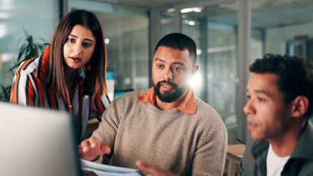 Night, review and people in office with computer, report guidance and feedback on draft article. Collaboration, flare and journalist at agency with tech, story ideas or blog deadline in late shift.の写真素材