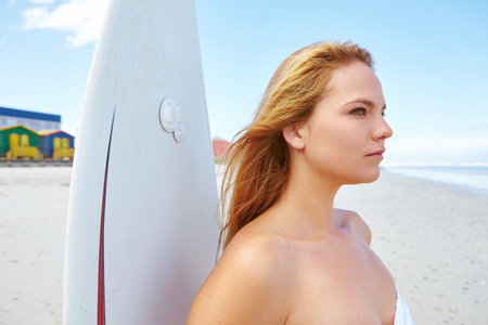 Surfboard, thinking and woman by beach for holiday, vacation or getaway in summer with adventure. Exercise, view and female person by ocean for surfing with fitness with water sports on weekend trip.の写真素材