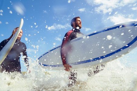 Ocean, surfboard and couple by beach on holiday, getaway or vacation together in summer. Splash,...