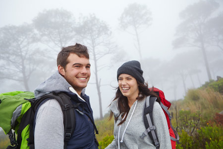 Couple, laughing and hiking in nature, backpacking and people on adventure, travel or happy in woods. Outdoor, man and woman with smile on trip, bonding and travelers in forest, together and vacationの写真素材
