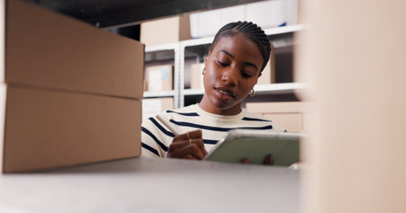 Ecommerce, tablet and stylus with black woman in warehouse for inspection, shipping and supply chain. Online checklist, quality assurance and inventory management with person for distributionの写真素材