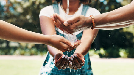 Water, hands and clean in nature for sustainability, wash or resource conservation. People, fingers or group splash with drops outdoor for hygiene, environment health or community support for ecologyの写真素材