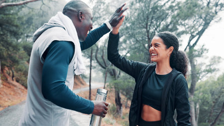 Fitness, people outdoor and high five with smile for workout achievement, exercise goals and milestone. Active, friends and happy with celebration in woods for training success, support and wellness.の写真素材