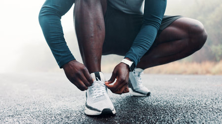Hands, person and tying laces for fitness routine, endurance training and running preparation. Athlete, runner and tie shoes for exercise safety, getting ready and sports workout for wellness outdoorの写真素材