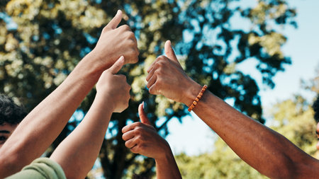 Below, outdoor and people with thumbs up, hands or university student with agreement. Closeup, group or friends with gesture, like or support for project, motivation or solidarity with icon or symbolの写真素材