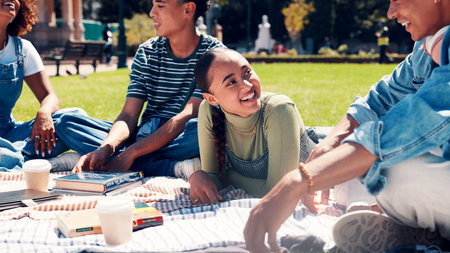 Education, study session or friends with blanket on campus, sharing knowledge or books for learning. Conversation, exam preparation or people together for support, outdoor or teaching for scholarshipの写真素材